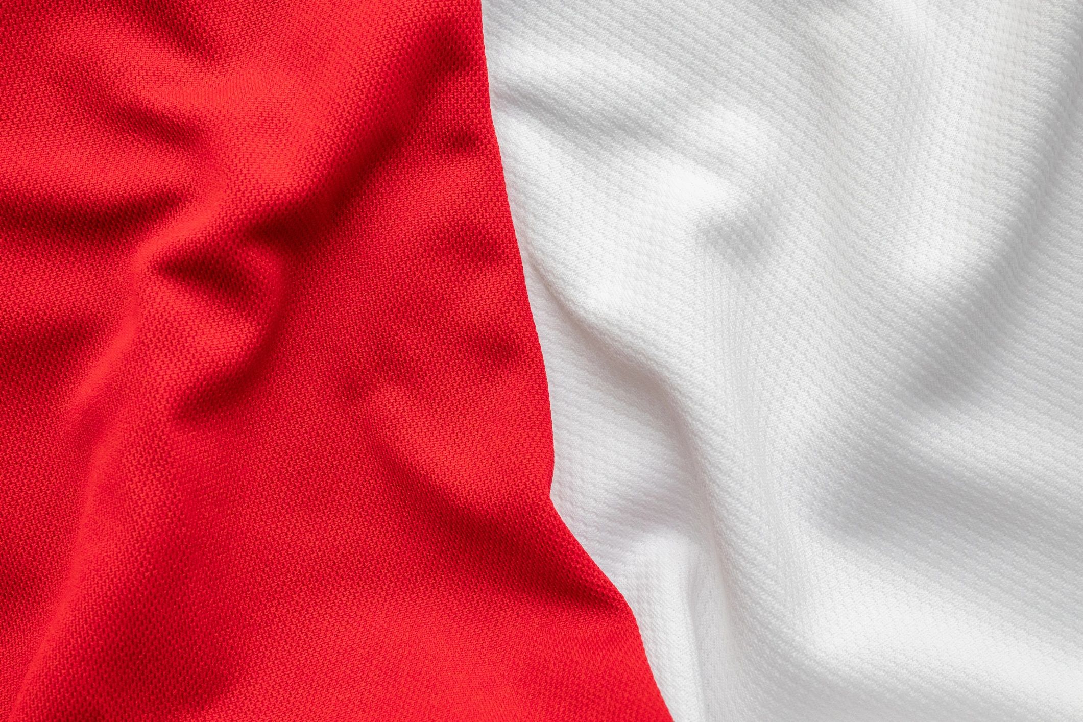 Red and white football jersey fabric texture closeup